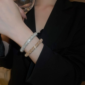 Detail of luxury gold and silver bangles with pavé crystals on a female wrist