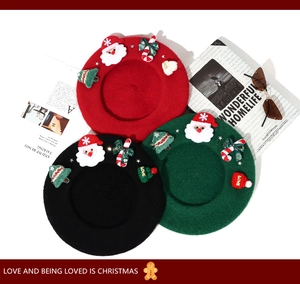 Detailed flat lay of wool berets in red black and green with festive Christmas charms