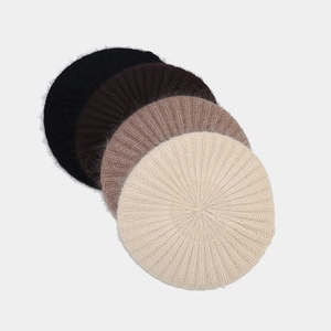 Detail of knit berets in black, brown, and cream showing rich fuzzy rabbit fur texture