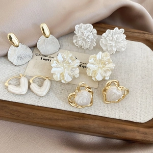 Detailed set of five vintage pearl and enamel stud earrings in gold and cream tones