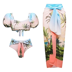 Detailed flat lay of three-piece tropical coconut palm print bikini and matching sarong