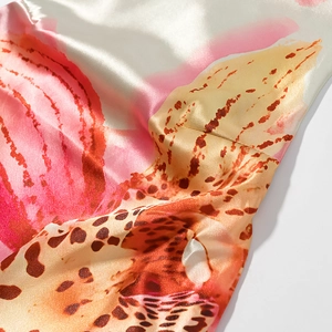 Gros plan sur le tissu en satin lisse avec des détails floraux et imprimé léopard