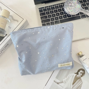 Flat lay of a light blue star pattern makeup bag with daily skincare essentials