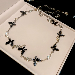Close-up of silver metal chain belt with black glitter butterfly charms and clear gems