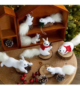 Detailed view of white faux fur squirrel figurines with pine cones and red scarves on wood