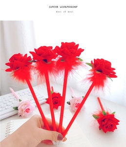 Creative rose-shaped ballpoint pens in red and pink velvet fabric held in hand