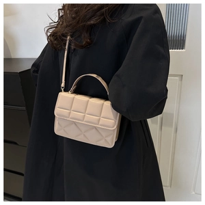 Beige quilted PU leather crossbody bag with top handle and shoulder strap on model