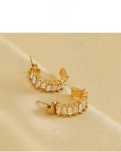 Detail of U-shaped gold earrings with rectangular zircon and 18K vacuum plating finish
