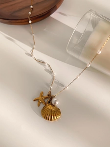 Detailed close-up of ocean-themed necklace with gold starfish, shell, and pearl charms