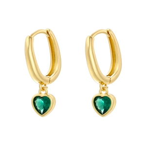 Close-up of golden geometric earrings featuring green heart-shaped crystal pendants