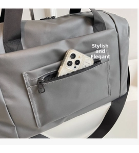Dettaglio della borsa da viaggio grigia con tasca frontale con zip per lo smartphone