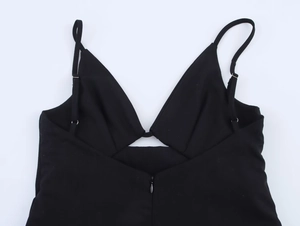 Dettaglio di un mini abito nero aderente con scollo a V e spalline sottili eleganti