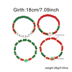 Dettaglio di quattro bracciali natalizi con ciondoli HO HO HO e perle di cristallo rosso