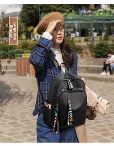 Detail shot of black waterproof nylon backpack with colorful LOVE letter print on straps