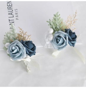 Detail of blue artificial rose boutonniere with gold leaves and white silk ribbons