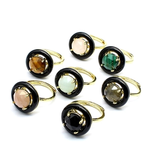 Luxurious gold rings set with colorful natural stones like malachite and sunstone on white background