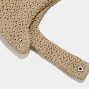 Close-up of khaki quilted winter hat flaps with zigzag stitching and silver metal snaps