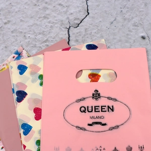 Detail of pink shopping bags with butterfly prints and cutout handles for gift packaging