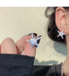 Close-up of sparkling star earrings with silver base and full cubic zirconia inlay