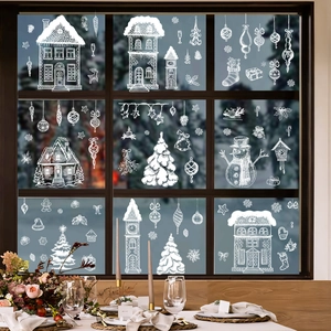 White Christmas window decals featuring snow houses and reindeer on a winter glass window