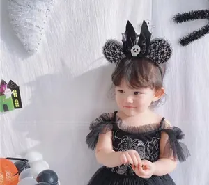 Detail of Halloween costume set featuring sequined black dress and bat skull headband