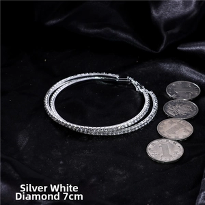 Silver oversized 7cm hoop earrings with white rhinestones on black silk background