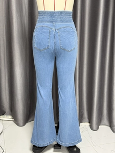 Detail view of high waist elastic waistband and back pockets on light blue denim jeans