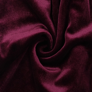 Close-up of deep burgundy velvet fabric showing rich texture and glossy light reflections