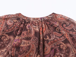 Close-up of paisley print chiffon neckline with delicate pleats and vibrant colors