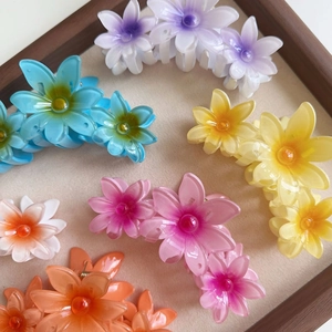 Summer candy color flower claw clips set with pearls on a wooden display tray