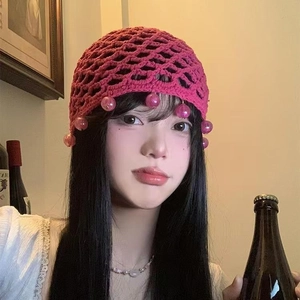 Pink handmade crochet beanie with hollow mesh pattern and dangling beads decoration