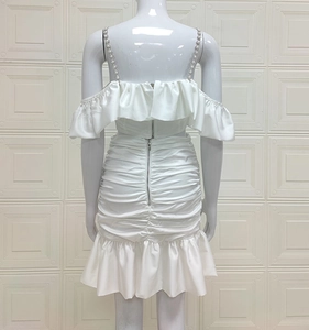 Detailed back view of white bodycon dress with pearl straps and zipper closure