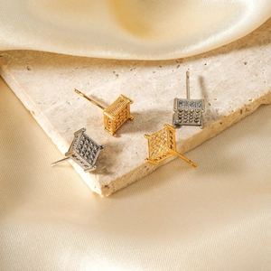 Square micro-paved zircon earrings in gold and silver finish on silk and marble base