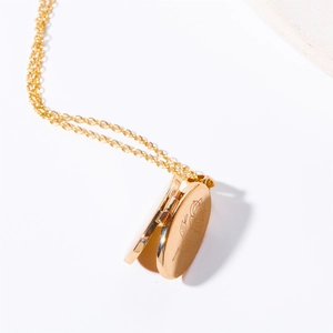 Detail of open gold oval locket necklace showing the internal photo storage compartment