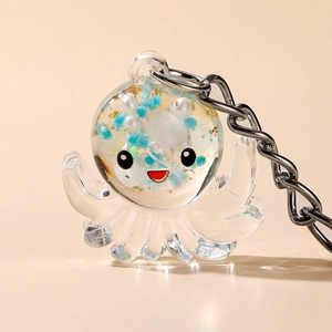 Macro detail of octopus acrylic keychain with blue beads and gold flakes inside