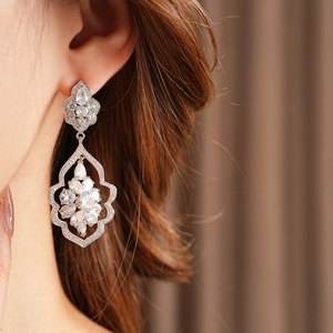 Gros plan de boucles d'oreilles pendantes fleurs en argent avec cristaux de zircon