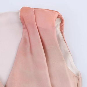Détail du col en V et plis aux épaules sur un tissu en satin rose dégradé soyeux