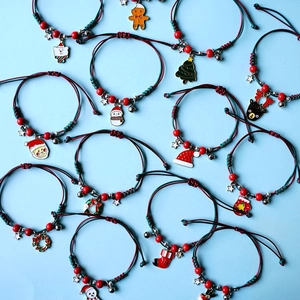 Detail view of handmade red and green woven Christmas bracelets with Santa Claus charms