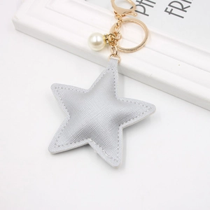Close-up of silver PU leather star keychain with gold clip and white pearl detail