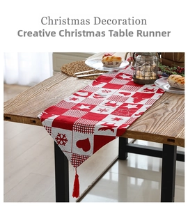 Detailed view of red and white Christmas table runner with elk motifs and fringe tassels