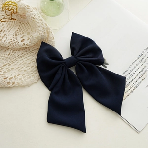Detail of elegant navy blue fabric bow hair clip on a vintage decorative background