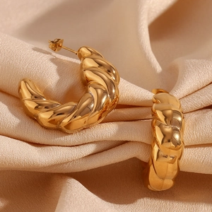 Detail shot of vintage hollow 18K gold-plated hammered texture earrings on silk