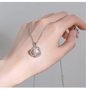 Close-up of a silver camellia pearl necklace with pavé cubic zirconia on o-chain
