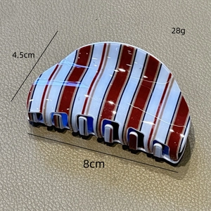 Detail view of red and white striped hair claw clip showing 8cm length and 4.5cm width