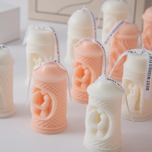 Detail showing hand-carved relief candles with elegant decorative ribbons in soft colors