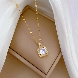 Macro view of gold-plated square pendant with sparkling crystals on soft beige velvet