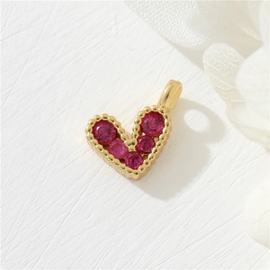 Elegant 14K gold plated heart pendant with micro-set red zircons on white floral surface