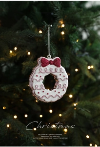Detail of pink and white donut wreath ornament with red bow on Christmas tree
