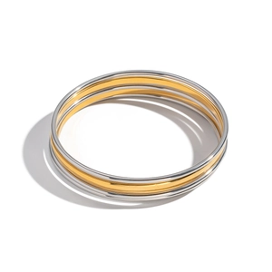 Detailed view of three minimalist polished gold and silver stainless steel bangles