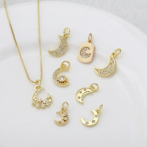 Set di gioielli dorati con pendenti a luna e stella su sfondo bianco minimalista